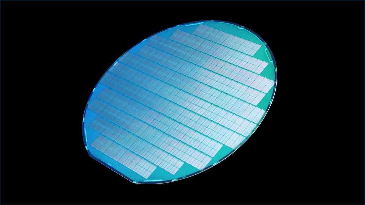 A large, blue semiconductor wafer with parallel lines is shown, symbolizing advanced chip technology.