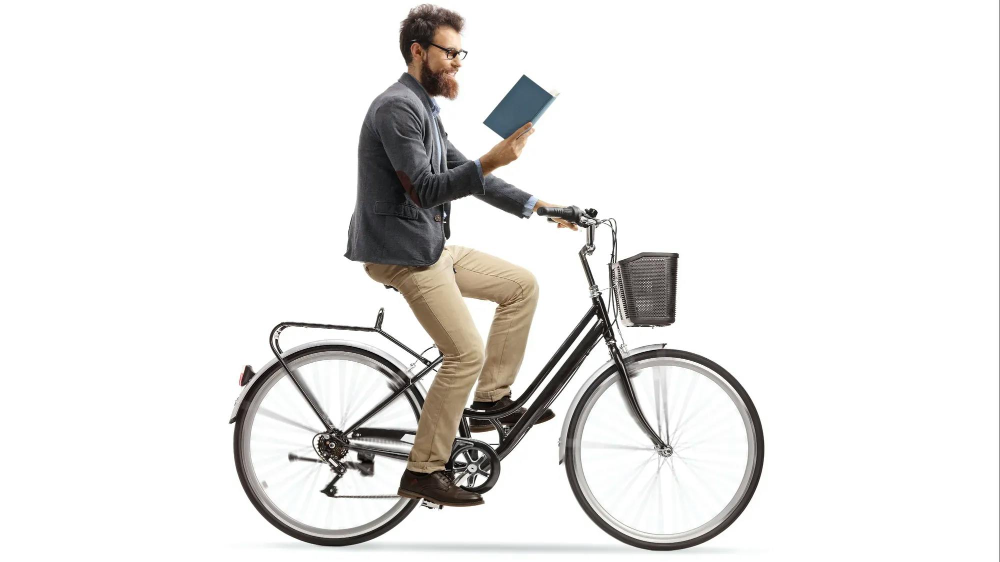 Man riding a bike and reading a book at the same time
