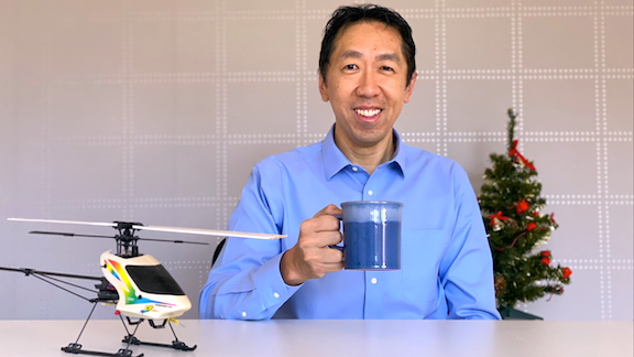 Andrew Ng holding a cup, small christmas tree behind
