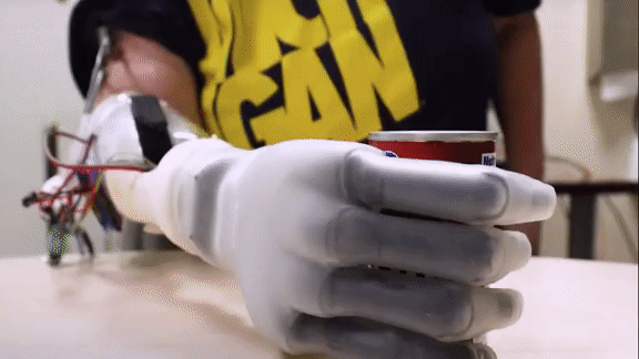 Robotic hand controlled by an amputee taking a can