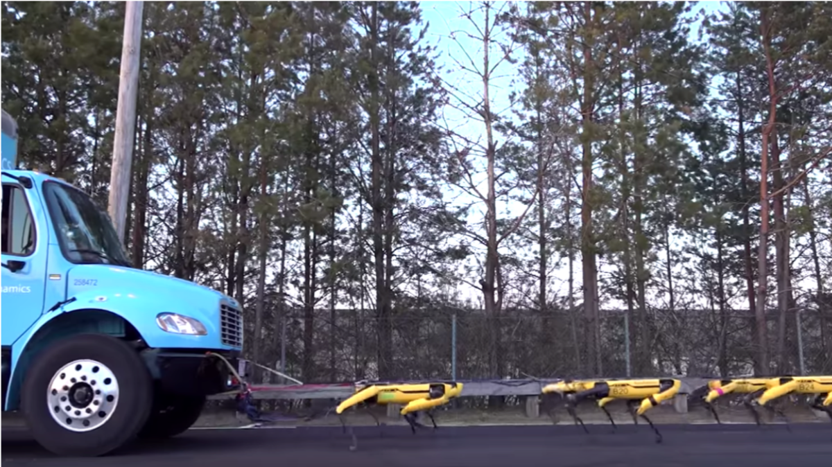 Boston Dynamics' robot dogs pulling a truck down a road