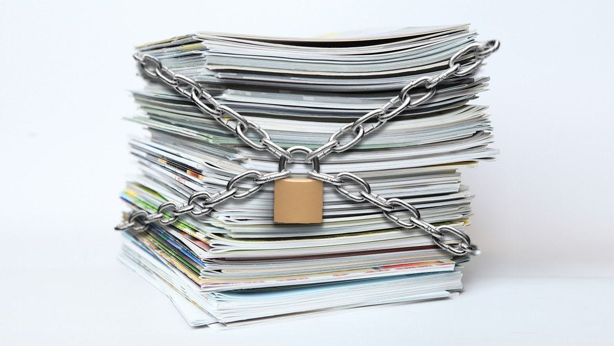 A stack of academic research papers are locked up with chains. 