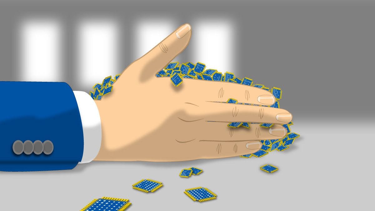A person's hand grabbing a handful of AI chips arranged on a table
